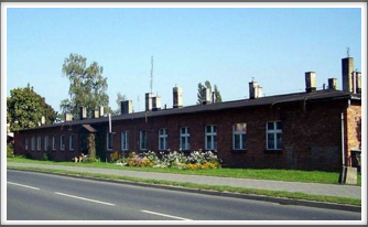 Former barracks across the street from Oflag 64, where the Germans were billeted. Note the dog in front of the building.
