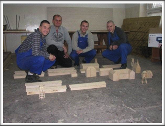 Teacher Tomasz Kmiec and boys from the carpentry shop pose with the scale models